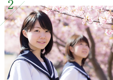 桜の下にいる女子生徒2人